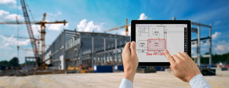 Engineer reviewing drawings on a tablet at a construction site